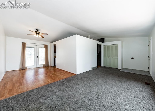 unfurnished living room with ceiling fan, french doors, carpet flooring, and lofted ceiling