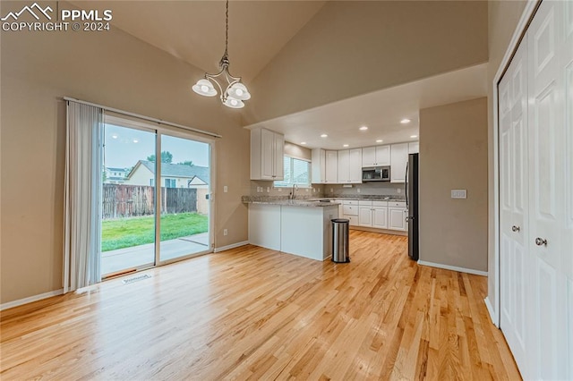 kitchen with high vaulted ceiling, white cabinetry, a chandelier, light hardwood / wood-style flooring, and fridge