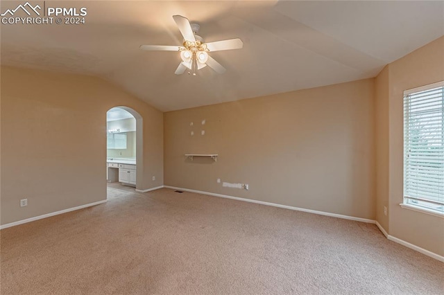 carpeted empty room with lofted ceiling and ceiling fan