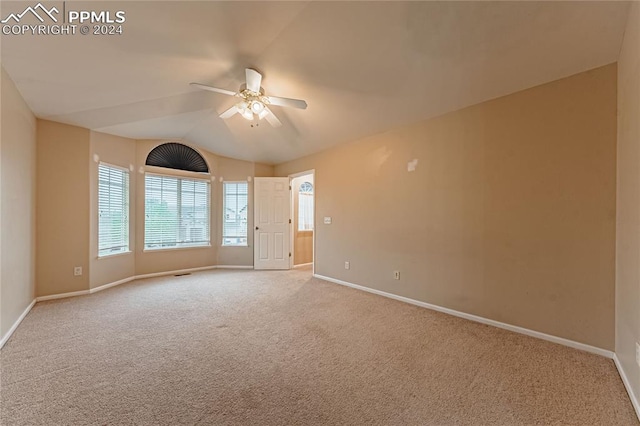 unfurnished room with vaulted ceiling, light colored carpet, and ceiling fan