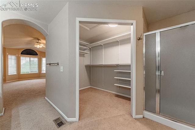 spacious closet featuring lofted ceiling, ceiling fan, and light colored carpet