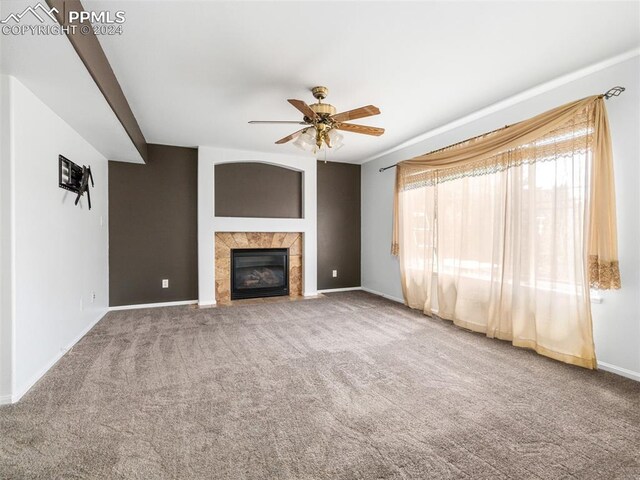 unfurnished living room featuring ceiling fan, a fireplace, and carpet floors