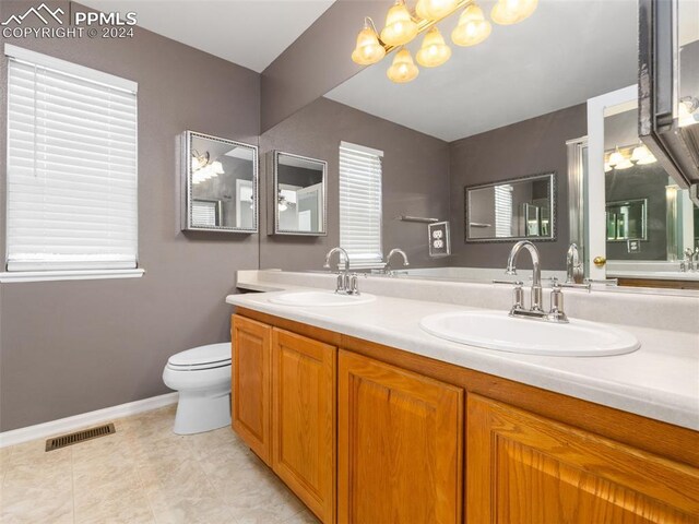 bathroom with dual vanity, tile patterned floors, and toilet