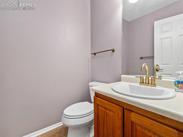 bathroom featuring toilet, tile patterned floors, and vanity