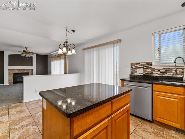 kitchen featuring decorative backsplash, light tile patterned flooring, stainless steel dishwasher, and a center island