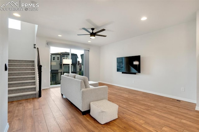 living room with light hardwood / wood-style floors and ceiling fan