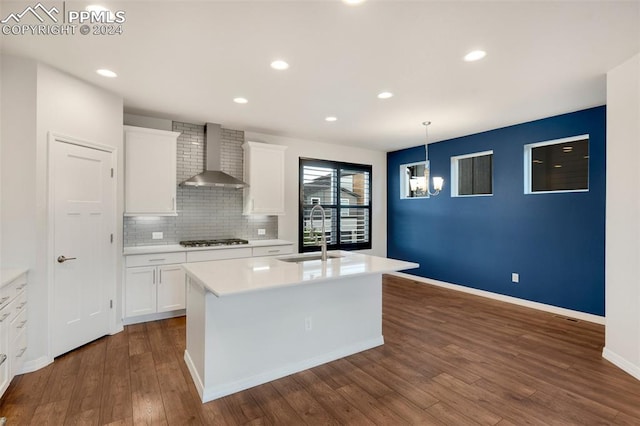 kitchen featuring white cabinetry, sink, dark wood-type flooring, and wall chimney range hood