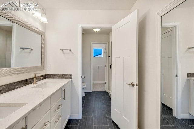 bathroom with tile patterned flooring, dual bowl vanity, and toilet