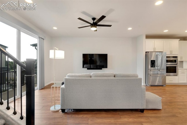 living room with ceiling fan and light hardwood / wood-style flooring