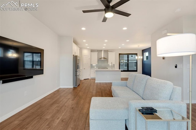 living room featuring ceiling fan, light hardwood / wood-style floors, and sink