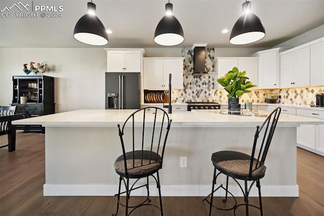 kitchen featuring a breakfast bar, white cabinetry, a kitchen island, decorative light fixtures, and high end refrigerator