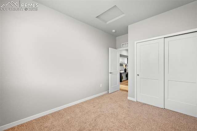 unfurnished bedroom featuring a closet and light colored carpet