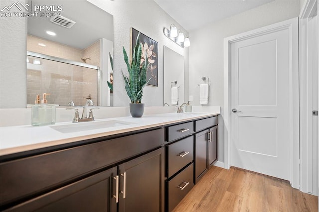 bathroom with vanity, hardwood / wood-style floors, and walk in shower