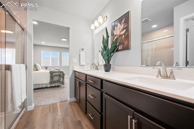 bathroom with hardwood / wood-style flooring, vanity, and walk in shower