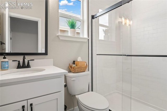 bathroom featuring an enclosed shower, vanity, and toilet