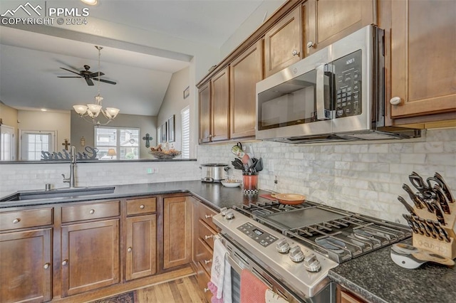 kitchen with light hardwood / wood-style floors, appliances with stainless steel finishes, sink, and tasteful backsplash