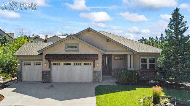 craftsman inspired home with a garage and a front lawn