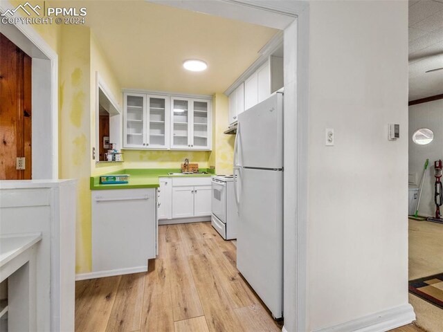 kitchen featuring white appliances, light hardwood / wood-style flooring, sink, and white cabinetry