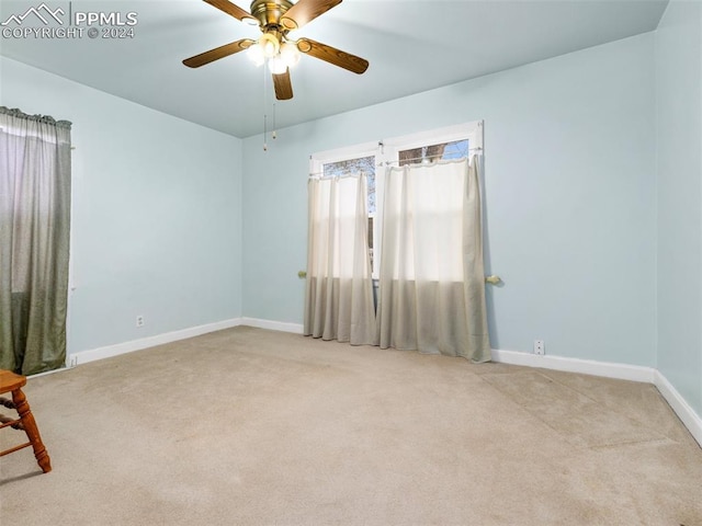 unfurnished room with light colored carpet and ceiling fan