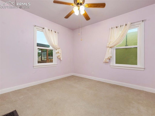 carpeted spare room featuring ceiling fan