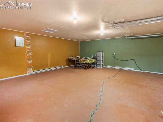 basement with baseboard heating and a textured ceiling