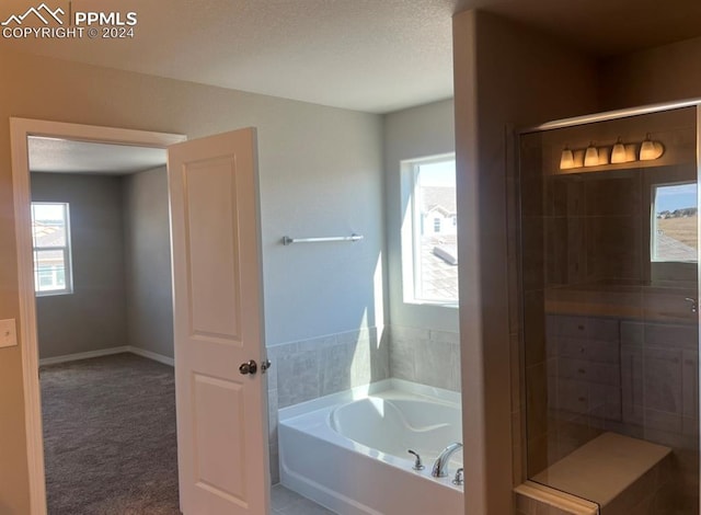 bathroom with plus walk in shower and a textured ceiling