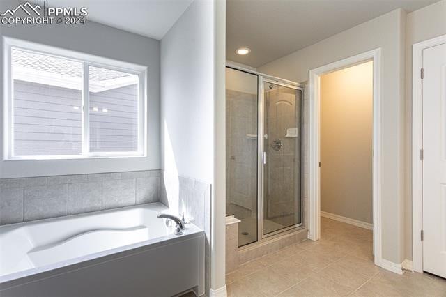 bathroom with independent shower and bath and tile patterned floors