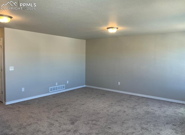 carpeted empty room with a textured ceiling