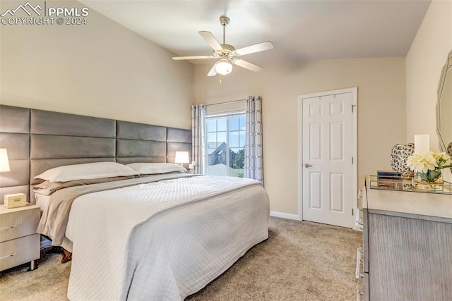 bedroom featuring ceiling fan, vaulted ceiling, and light carpet