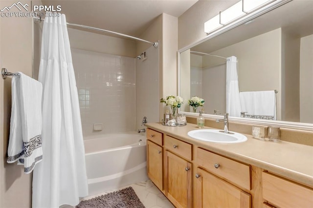 bathroom featuring tile patterned flooring, shower / bath combo with shower curtain, and vanity