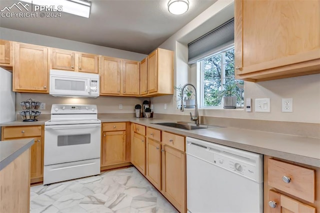 kitchen with sink, white appliances, light tile patterned floors, and light brown cabinets