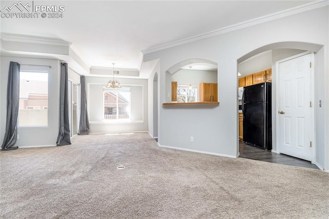 unfurnished living room featuring a chandelier, dark colored carpet, plenty of natural light, and baseboards