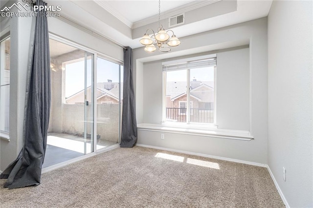 empty room featuring carpet floors, a tray ceiling, visible vents, ornamental molding, and baseboards