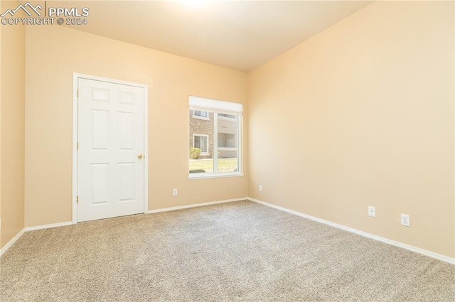 carpeted empty room featuring baseboards