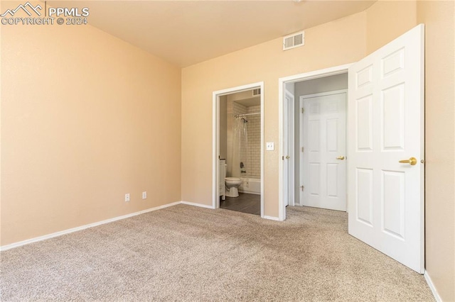 unfurnished bedroom with baseboards, visible vents, carpet flooring, and ensuite bathroom