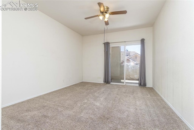 carpeted empty room featuring ceiling fan and baseboards