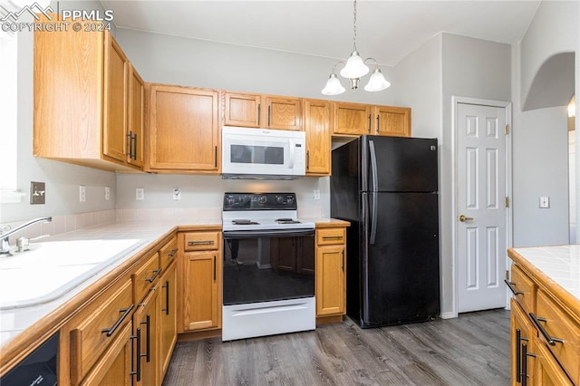 kitchen featuring white microwave, dark wood-style flooring, range with electric cooktop, a sink, and freestanding refrigerator