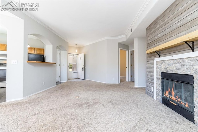 unfurnished living room featuring crown molding, light carpet, a fireplace, and baseboards