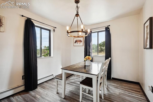 dining area featuring a baseboard heating unit, wood-type flooring, and a chandelier