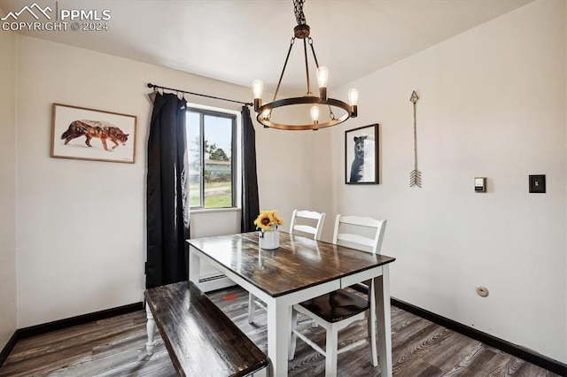 dining area featuring a notable chandelier, baseboard heating, and dark hardwood / wood-style floors