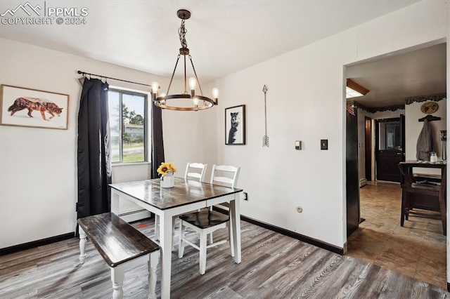 dining space featuring tile patterned flooring, a notable chandelier, and a baseboard heating unit