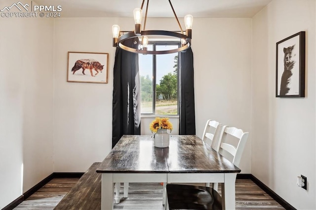 dining area with dark wood-type flooring and a chandelier