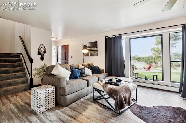 living room with ceiling fan, a baseboard heating unit, and wood-type flooring