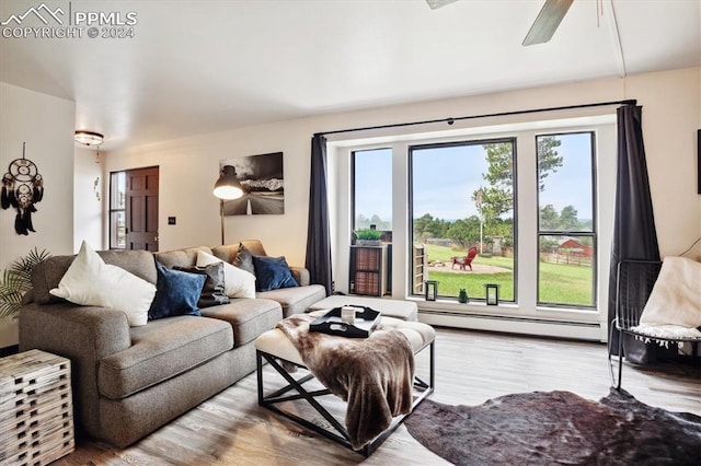 living room with light wood-type flooring and a baseboard heating unit