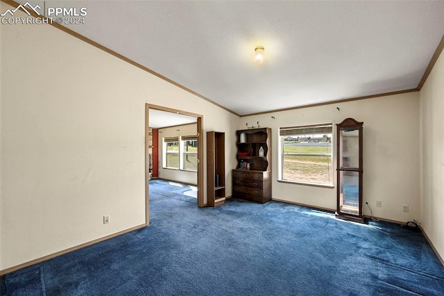 empty room with carpet floors, crown molding, and vaulted ceiling