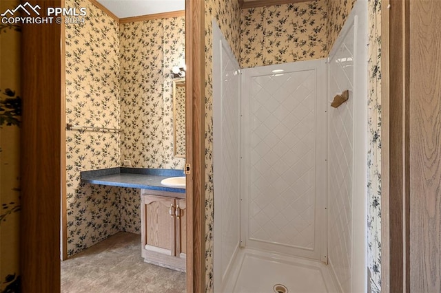 bathroom featuring tile patterned floors, ornamental molding, walk in shower, and vanity