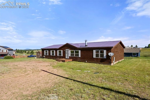 view of front of home featuring metal roof, a front yard, and fence