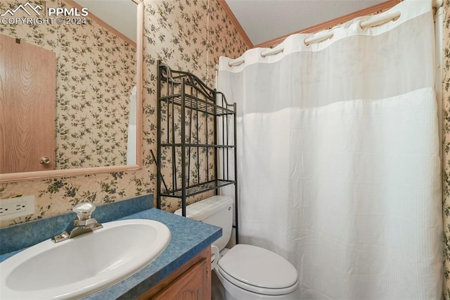 full bathroom with vanity, toilet, and wallpapered walls