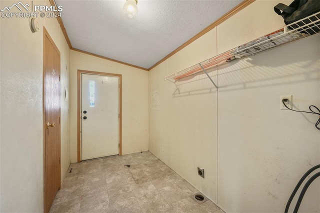 laundry room with laundry area, crown molding, and a textured ceiling