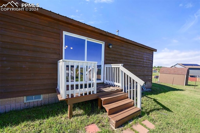 rear view of house with a wooden deck and a yard